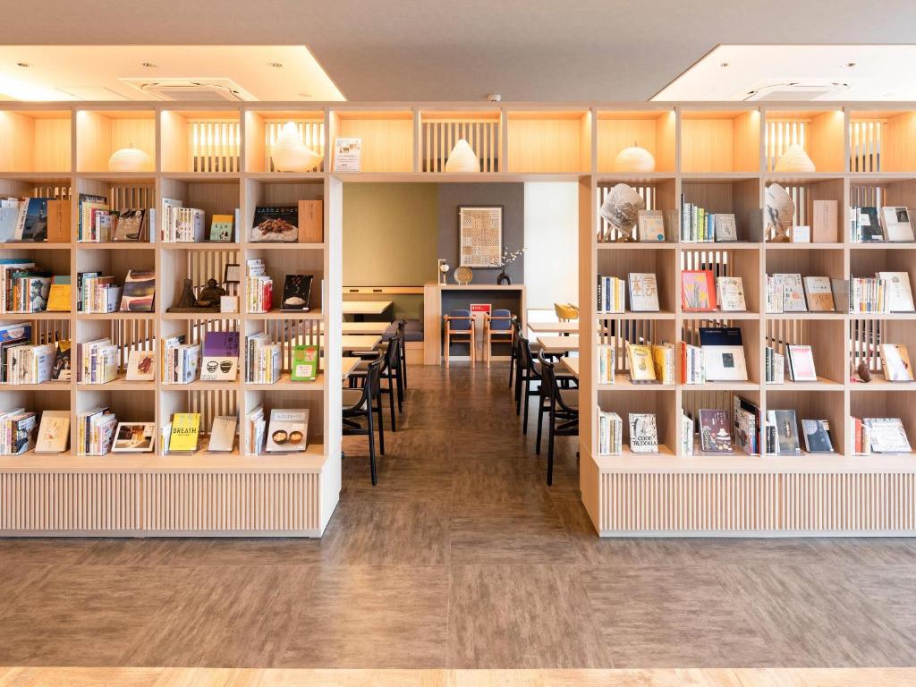 a library with shelves filled with books at Comfort Hotel Mito in Mito