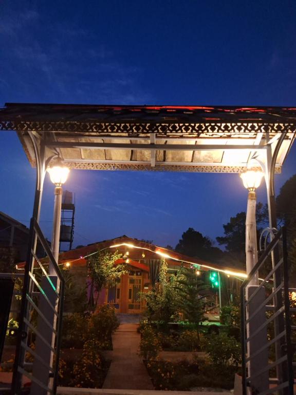 un arco con luces delante de un edificio en TATHASTU RETREAT BiR -TRB, en Bīr