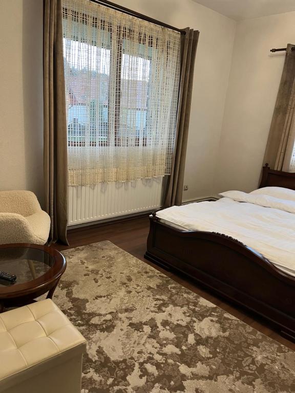 a bedroom with a bed and a large window at Casa Craiului in Zărneşti