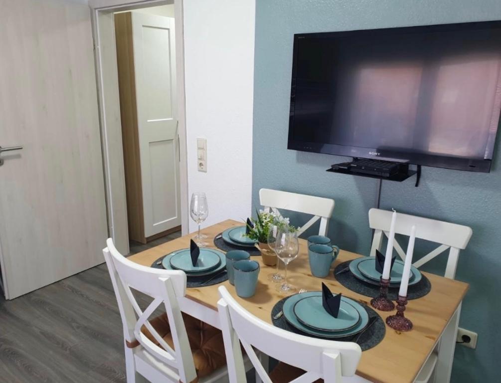 a dining room table with chairs and a television at FeWo Hess in Rust