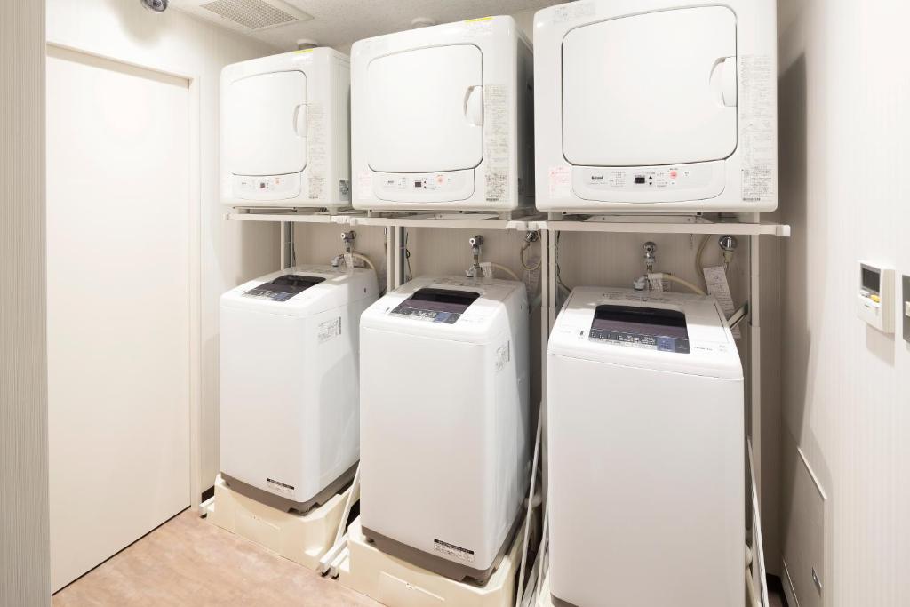 four washers and dryers on a shelf in a room at Hotel Mystays Premier Akasaka in Tokyo