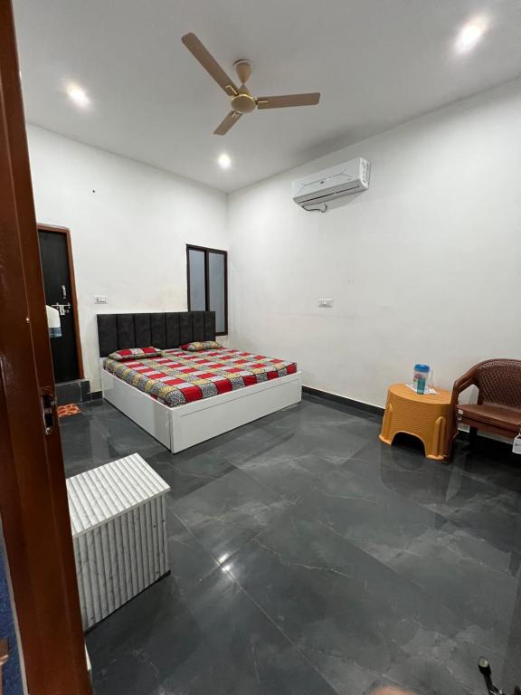 a bedroom with a bed and a ceiling fan at Kamal Kishori Dham in Barsāna