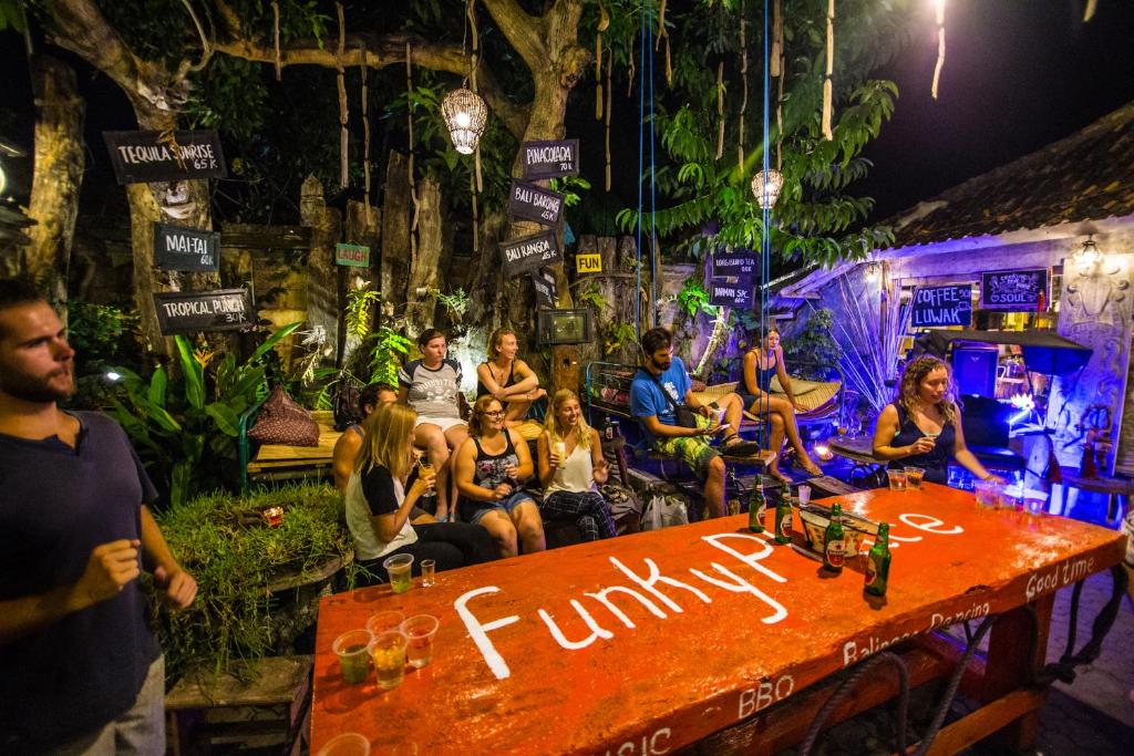 un grupo de personas sentadas alrededor de una mesa en Funky Place, en Lovina