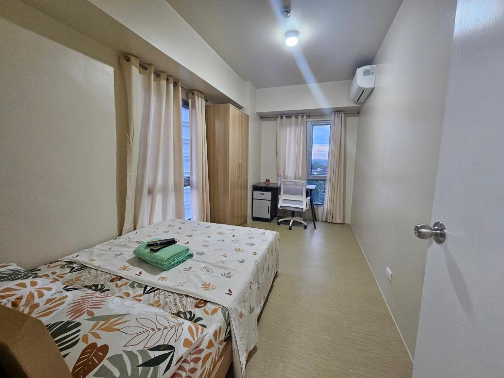 a room with a bed and a desk in a room at Avida Abreeza 1bedroom with balcony in Davao City