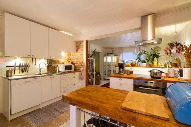 a large kitchen with white cabinets and a counter top at Villa Virpi in Rovaniemi