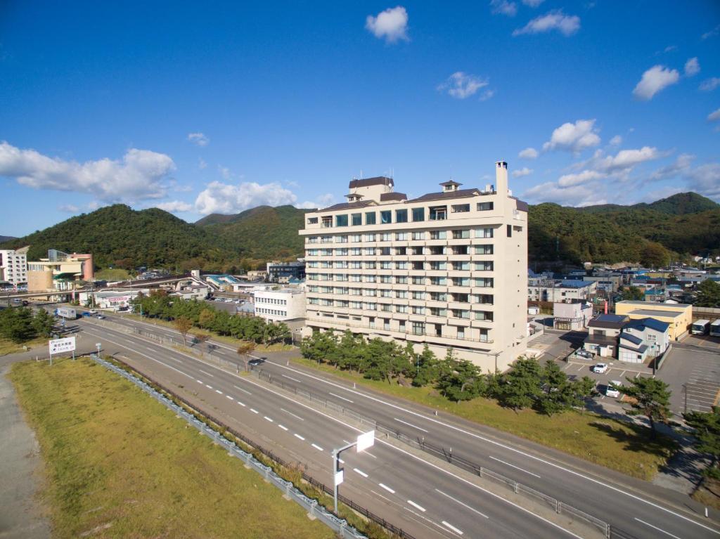 a large white building next to a highway at Kaisenkaku in Aomori