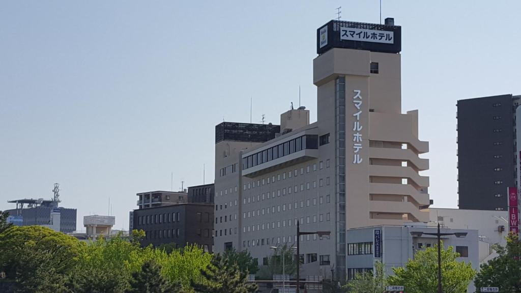 a tall building with a sign on top of it at Smile Hotel Wakayama in Wakayama