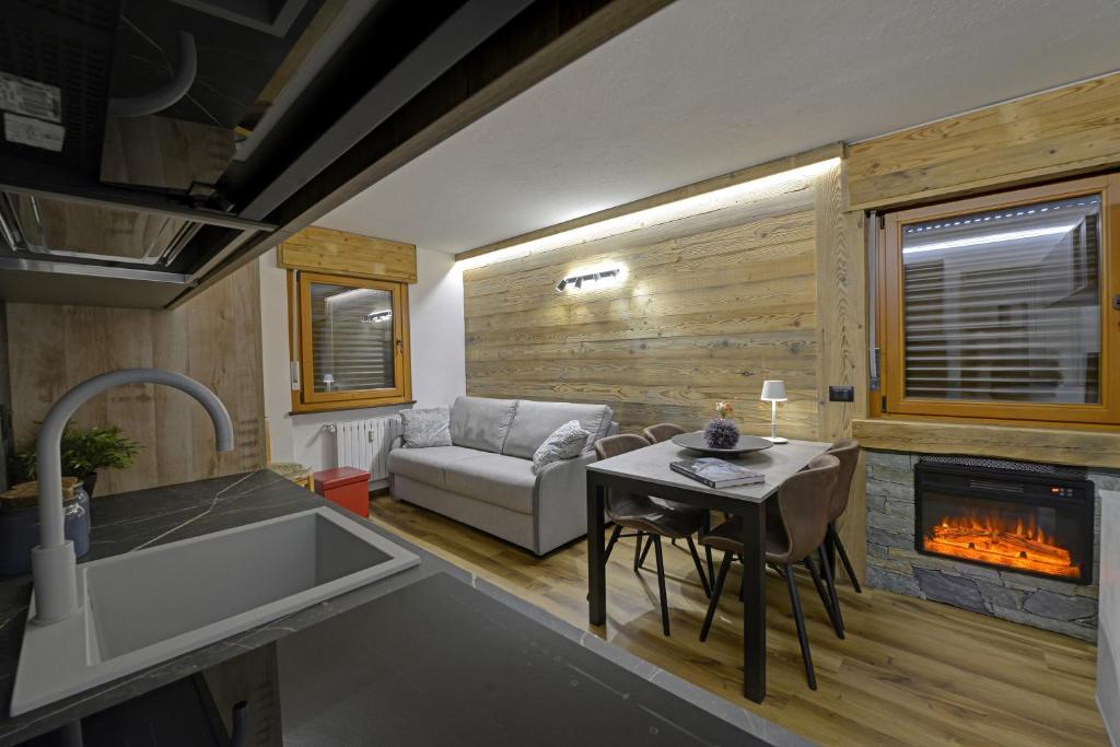 a kitchen and a living room with a fireplace at Maison Henri in Morgex