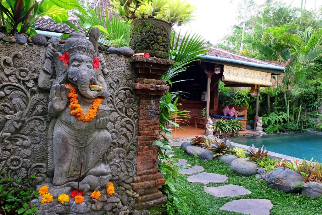 een standbeeld van een olifant aan de zijkant van een huis bij Honeymoon Green Villa in Ubud