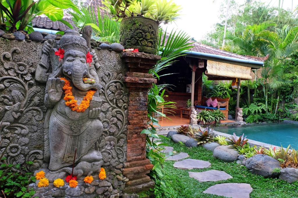 a statue of an elephant on the side of a house at Honeymoon Green Villa in Ubud