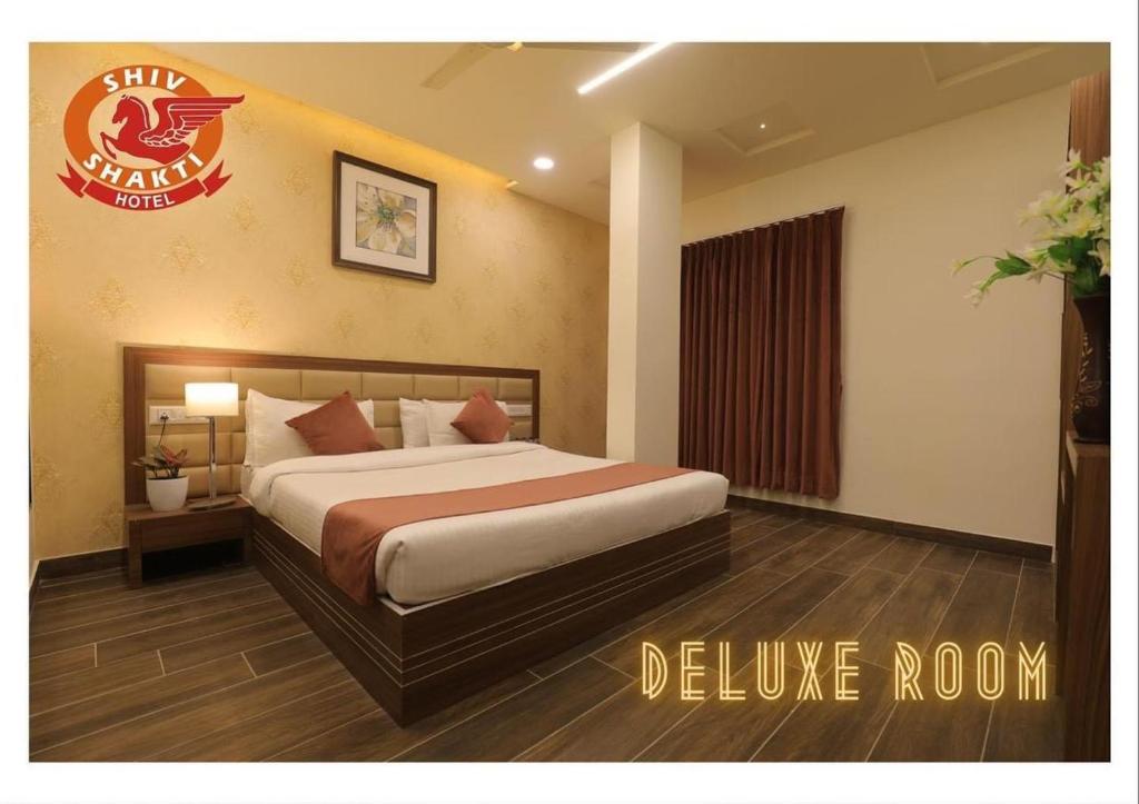 una camera con un letto in una camera d'albergo di Hotel Shiv Shakti a Rajkot