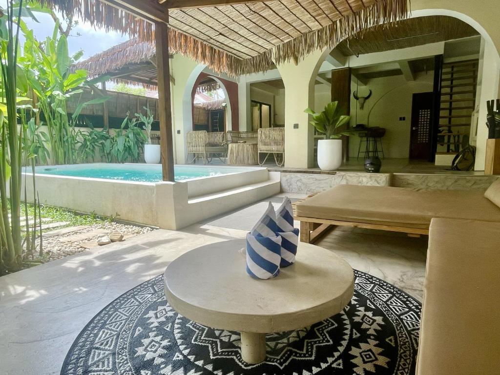 DILAW Villa avec piscine privée في إل نيدو: فناء به مسبح وطاولة عليها مزهرية