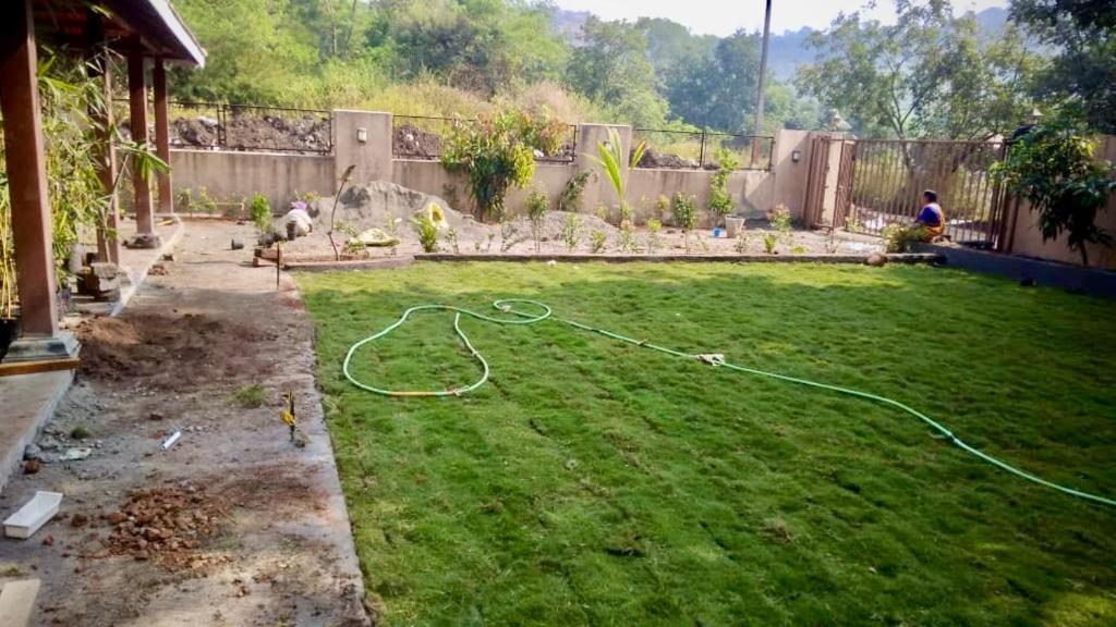 a yard with a hose laying on the grass at Parijat Villa - A Perfect Weekend Getaway in Pune