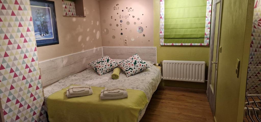 a small bedroom with a bed with two pillows at La chambre des As in Durbuy