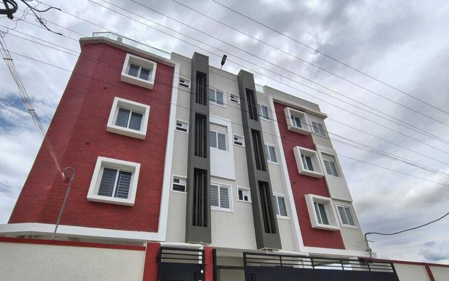 a red and white building with a red at Hotel O Oragadam Industrial Estates Chennai Formerly SSM Rooms in Oragadam