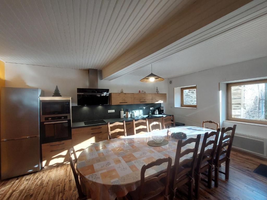 eine Küche und ein Esszimmer mit Tisch und Stühlen in der Unterkunft Au petit hameau Cabrespine in Cabrespine