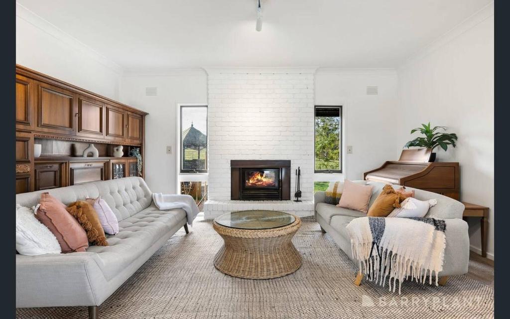 Yarra Valley farmstay - wine views في Tarrawarra: غرفة معيشة مع كنبتين ومدفأة