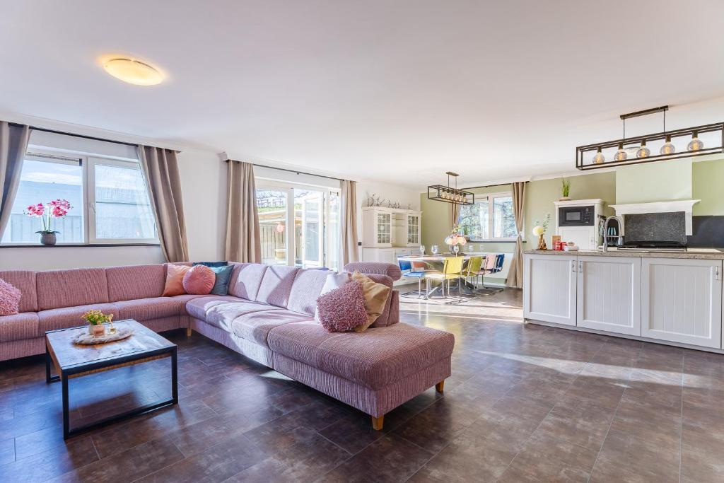ein Wohnzimmer mit Sofa und Tisch in der Unterkunft Welcome in - Vakantiewoning Keetenweg 10 I Met airco en omheinde tuin in Stavenisse