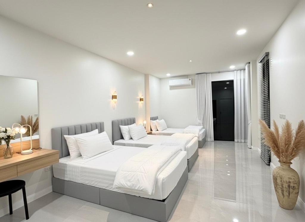 una camera con due letti e un divano in camera di พูลวิลล่าบุรีรัมย์ a Ban Krasang