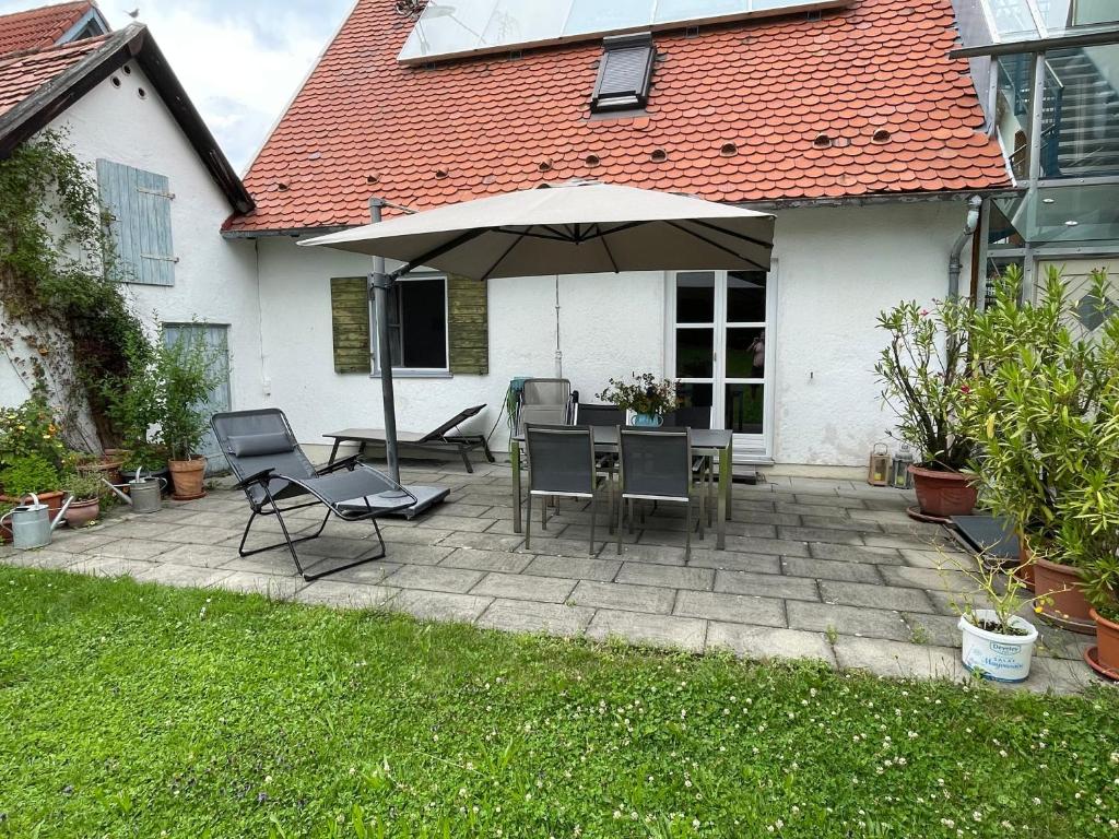 a patio with a table and an umbrella at Ferienwohnung Maslanka EG in Utting am Ammersee