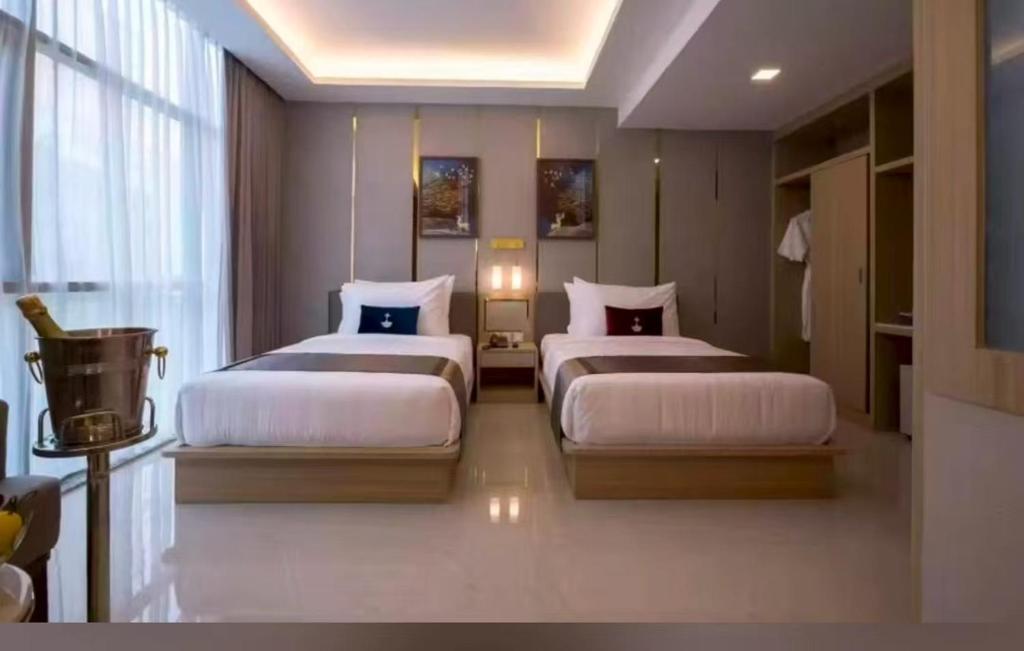 Un dormitorio con dos camas en una habitación. en Lee Airport Hotel 李酒店机场店, en Phrawet