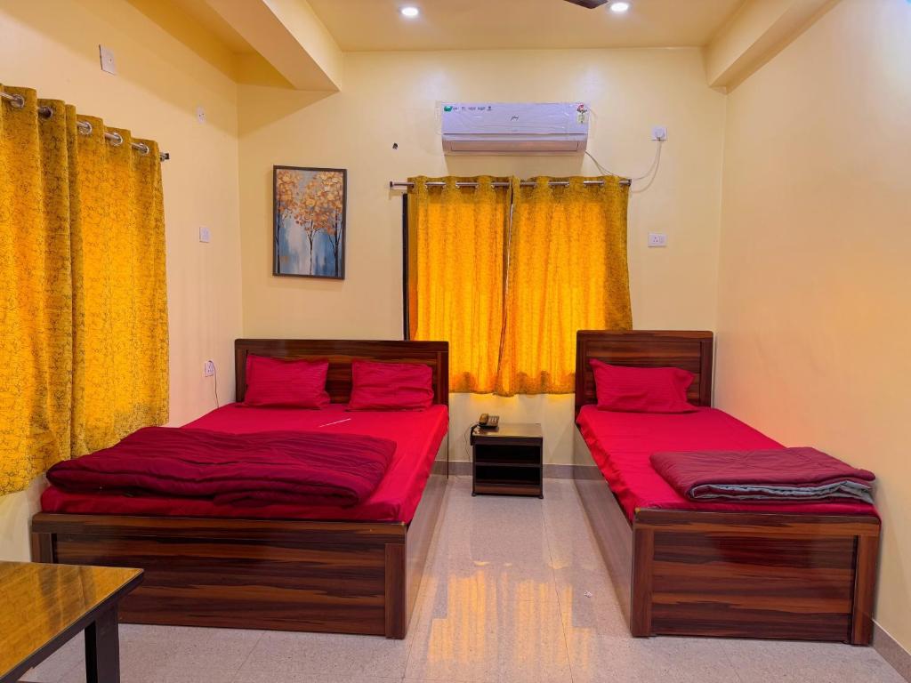 zwei Einzelbetten in einem Zimmer mit gelben Vorhängen in der Unterkunft Studio 306 Royal Urban in Deoghar