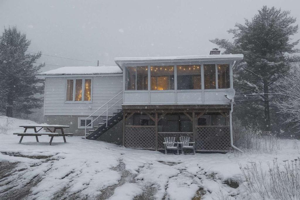 a house with a picnic table in the snow at Georgian Bay 3-bdrm lakefront Main House in Dillon