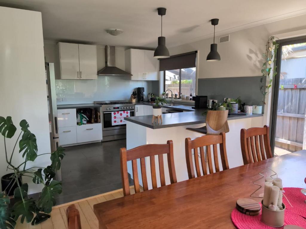 Una cocina y un comedor con mesa y sillas. en Capel Breeze, en Capel Sound