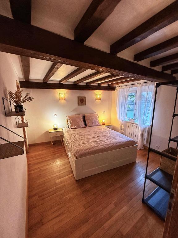 a bedroom with a bed and a wooden floor at Chez l'Alsacienne in Andlau