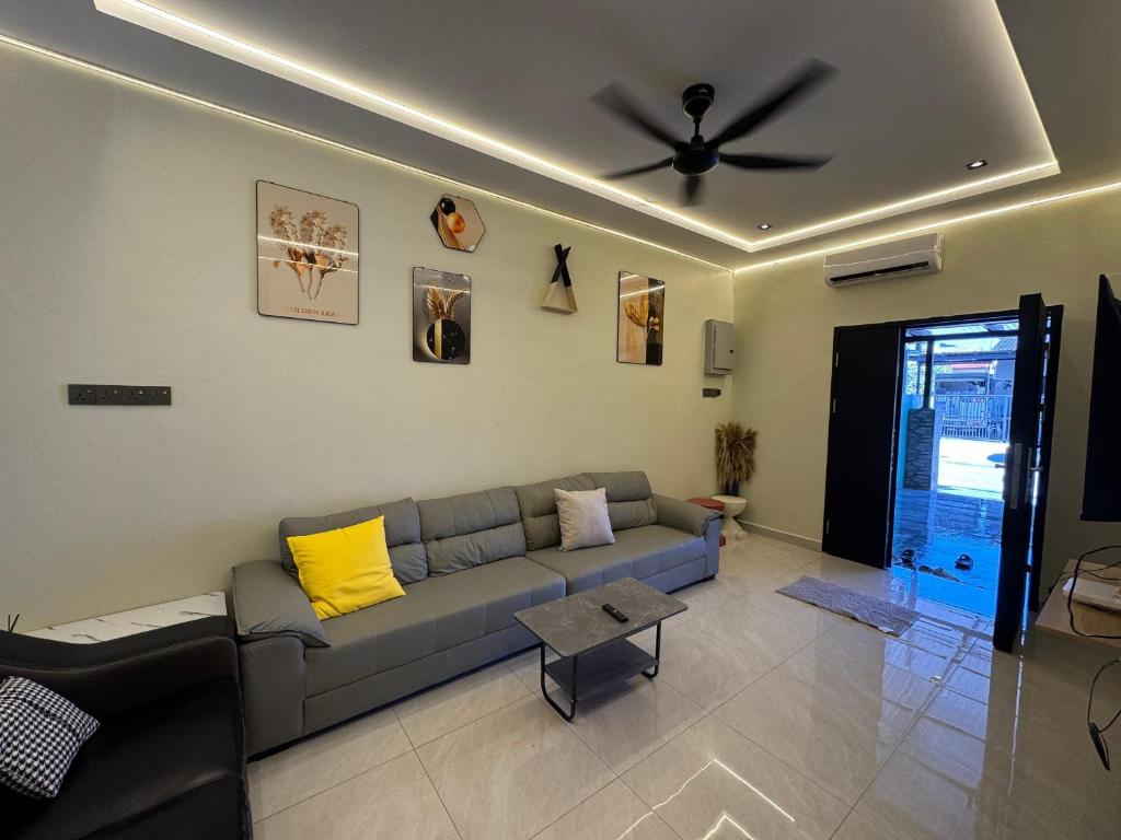 Una sala de estar con un sofá y un ventilador de techo. en Ipoh Spacious Comfort Staycation Homefeel free WIFI TK9, en Ipoh