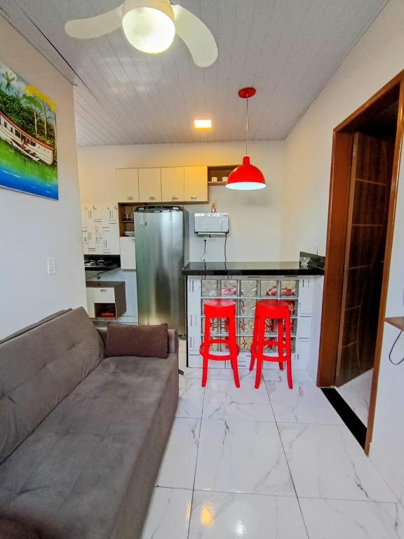 a living room with a couch and two red chairs at Apartamento novo e confortável in Belém