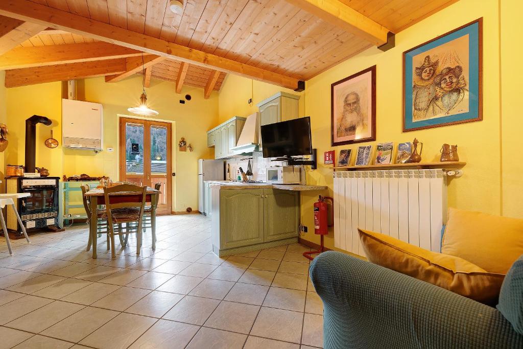 a kitchen and a living room with a couch and a table at Casa Aliza - Duplex Alpino in Pieve di Bono