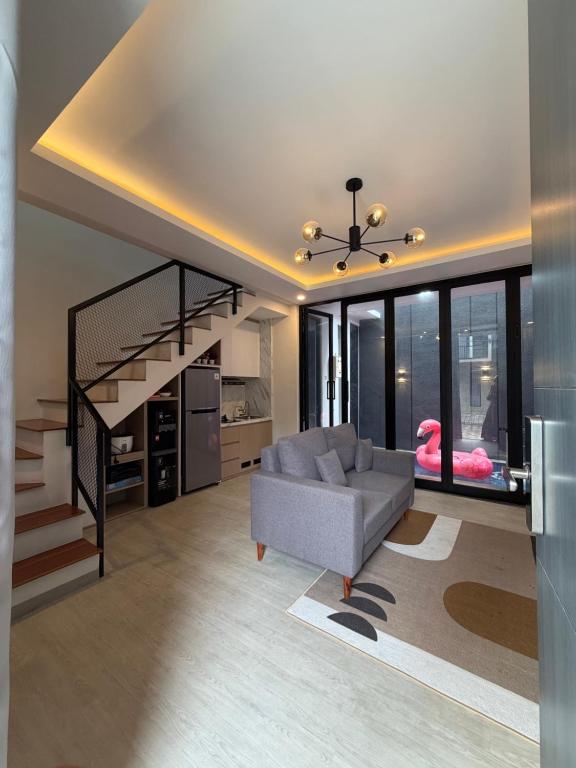 Una sala de estar con un sofá y una escalera. en NZ Villa Guesthouse Aesthetic Batu, en Malang
