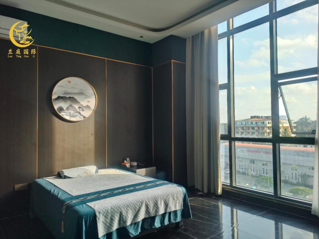een slaapkamer met een bed en een groot raam bij Lan Ting massage hotel in Dar es Salaam