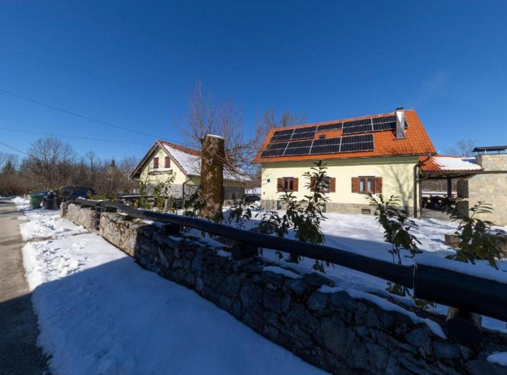 una casa con pannelli solari sul tetto nella neve di Lovinac Spa by Režek a Lovinac