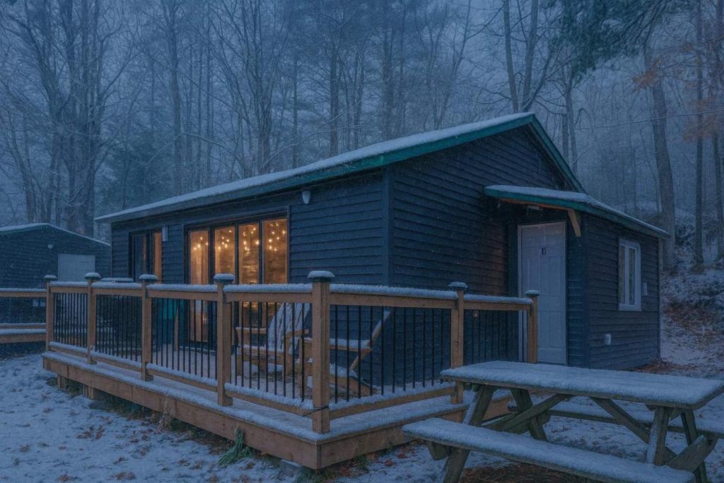 a log cabin with a bench and a table at 2-Bedroom Cottage #11 - Red Pine in Gravenhurst