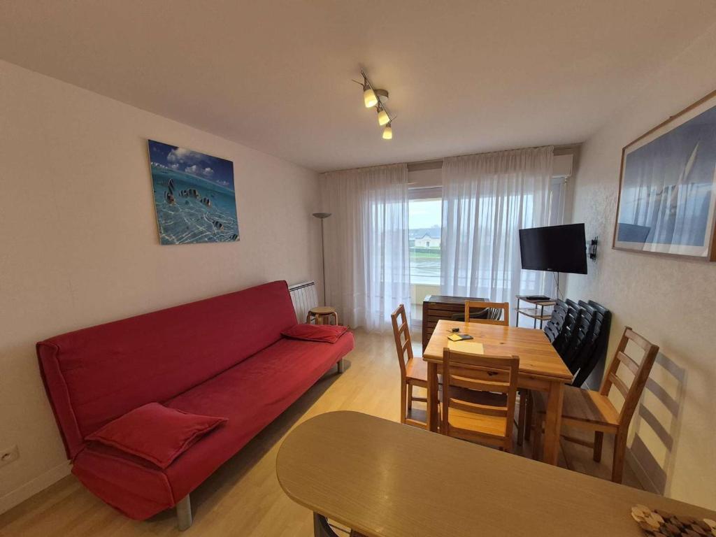 a living room with a red couch and a table at Confortable appartement 4 personnes avec balcon, parking à Stella Plage - FR-1-236-173 in Stella-Plage