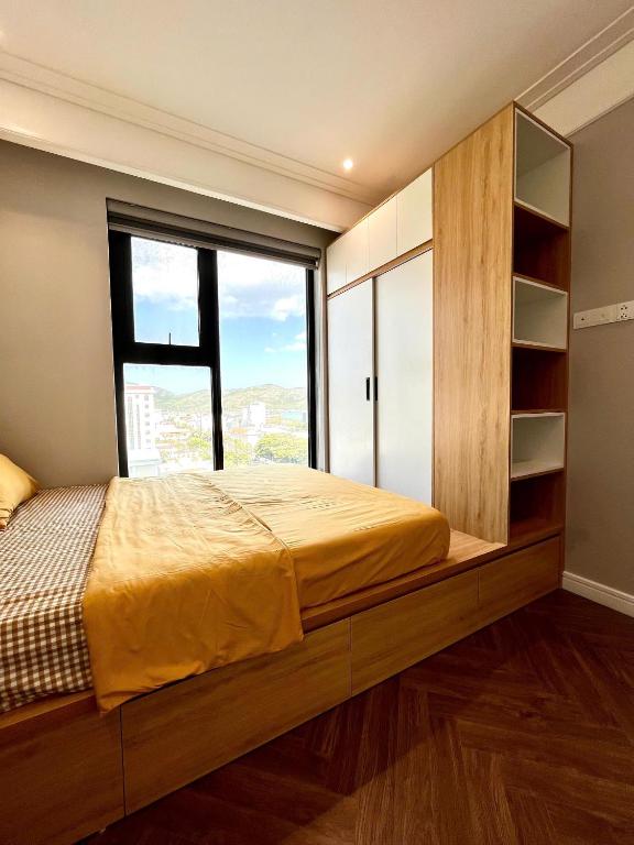 a bedroom with a bed and a large window at Quy Nhon Alt cosy apartment in Quy Nhon