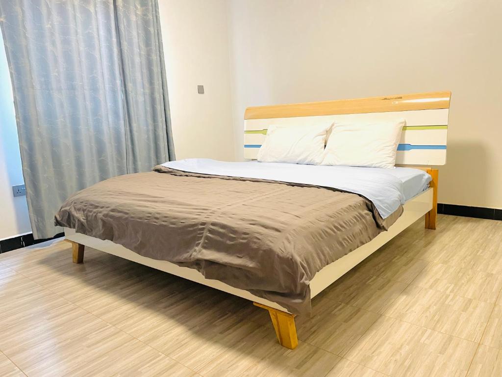 - un lit avec une tête de lit en bois dans l'établissement Zuri stays, à Kampala