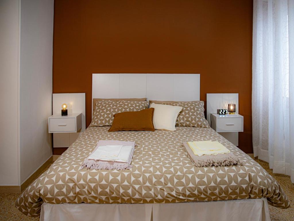 La Corte Del Pane في Corridonia: غرفة نوم بها سرير كبير وطاولتين جانبيتين