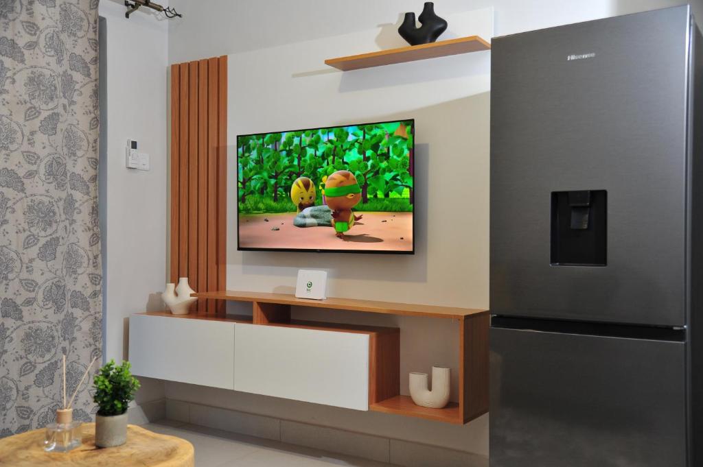 a living room with a flat screen tv on a wall at Sentlhaga 1 Bed Self Catering Apartment, Sarona City,Habitat Kappa, Gaborone in Gaborone