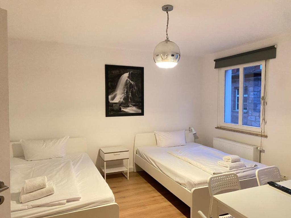 a small room with two beds and a window at Apartment an der Dürerstraße in Nuremberg