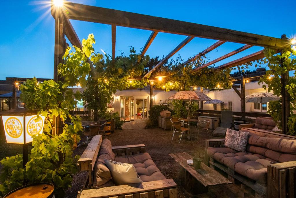 a patio at night with couches and tables at B&B Katoo in Linne