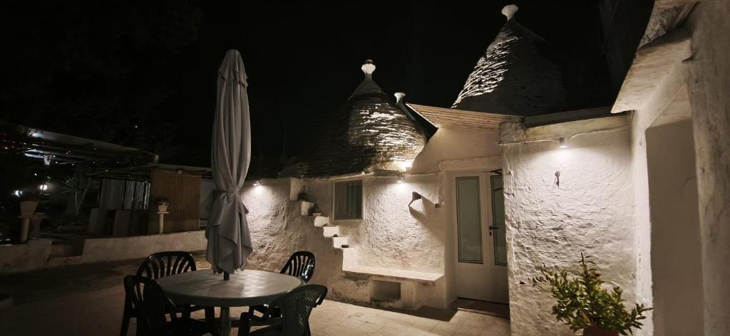 a table and umbrella on a patio at night at Il trullo della nonna in Martina Franca