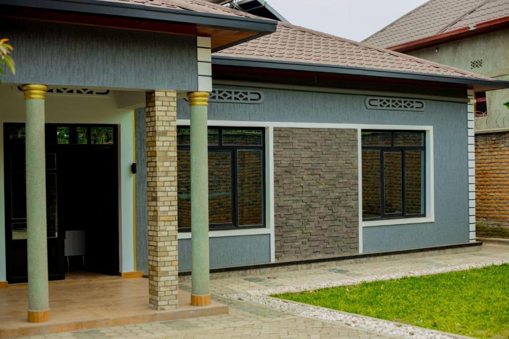 a house with a front porch with a door at Happy Home House in Ruhengeri