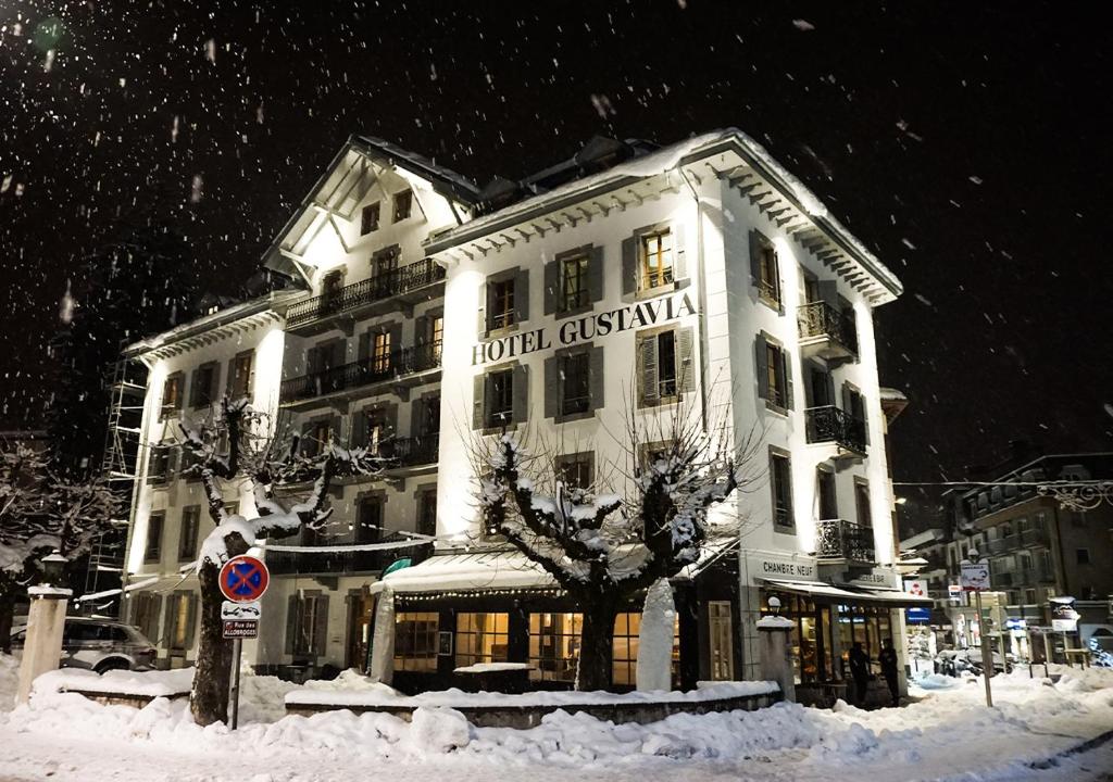 a large white building in the snow at Langley Hotel Gustavia in Chamonix-Mont-Blanc