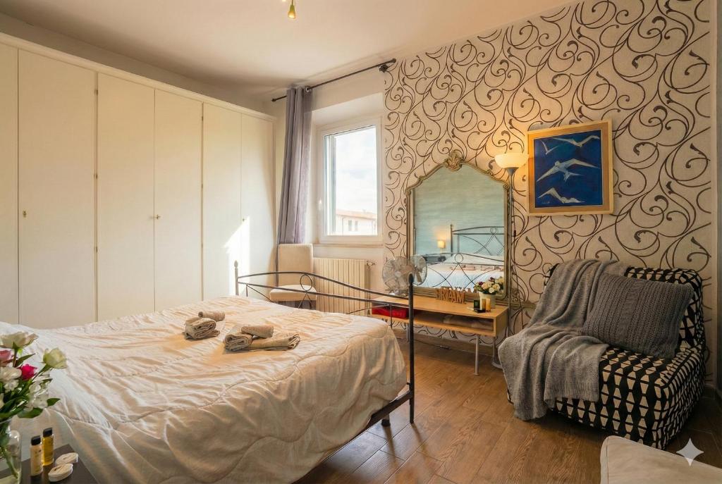 ein Schlafzimmer mit einem Bett, einem Spiegel und einem Stuhl in der Unterkunft L'originario Salviano Family Apartment in Livorno