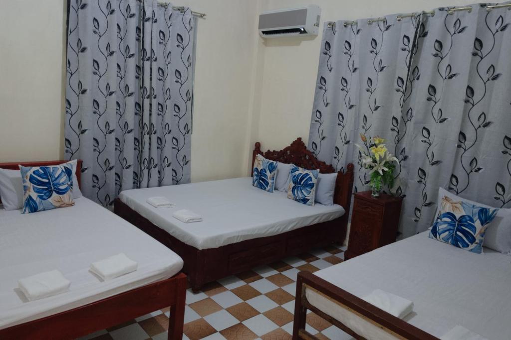 a room with two beds and a window with curtains at Besañes Homestay in Alaminos