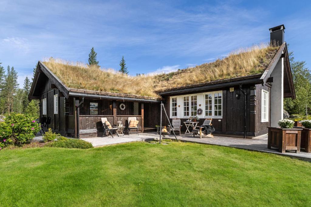 een huis met een grasdak met een terras bij Charming cabin in Hemsedal Golf Alpin - ideal for families, fishing & skiing in Granheim