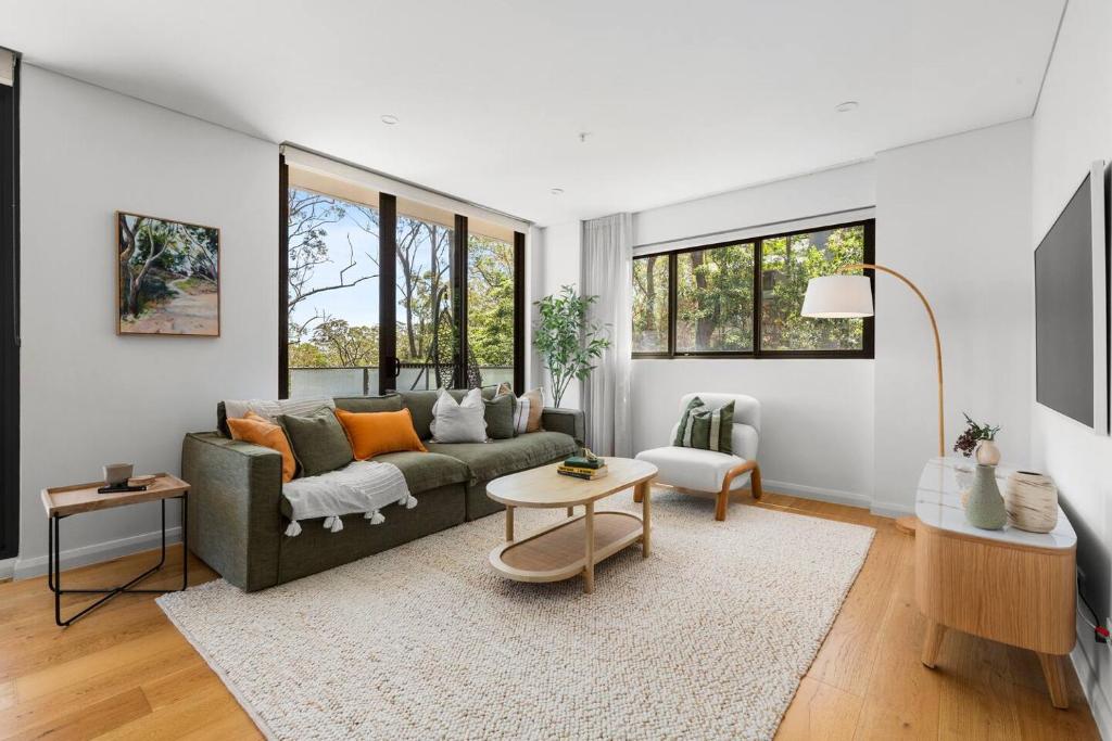 ein Wohnzimmer mit Sofa und Tisch in der Unterkunft Upper North Shore Haven - A Tranquil Treetop Escape in Warrawee